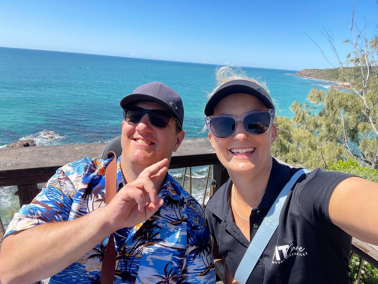 A FITCare support worker and participant smile at a coastal lookout after an outing
